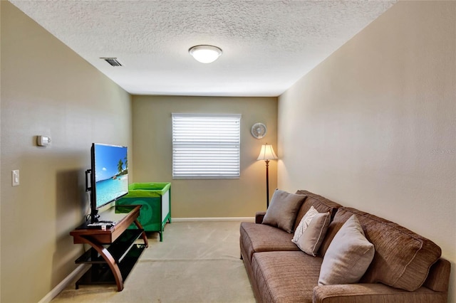 carpeted living room featuring a textured ceiling