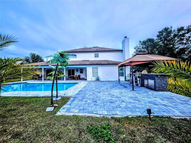 view of pool with area for grilling and a patio