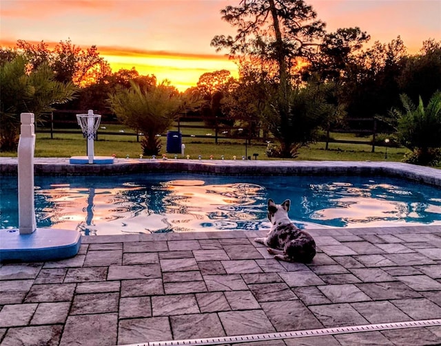 pool at dusk with a patio