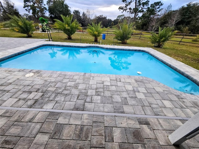 view of swimming pool with a patio area and a lawn