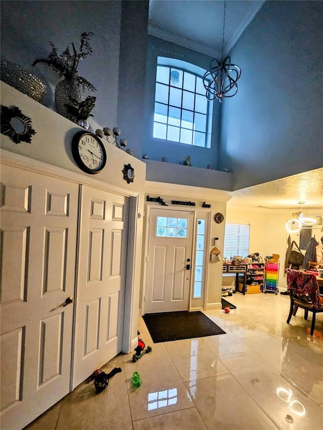 entrance foyer featuring a notable chandelier, a high ceiling, and ornamental molding