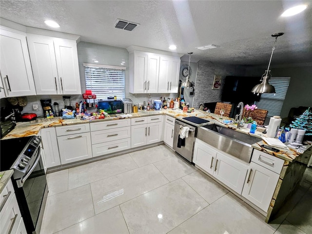 kitchen featuring stainless steel appliances, white cabinetry, and hanging light fixtures