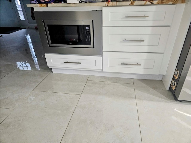 interior details featuring white cabinets and stainless steel microwave