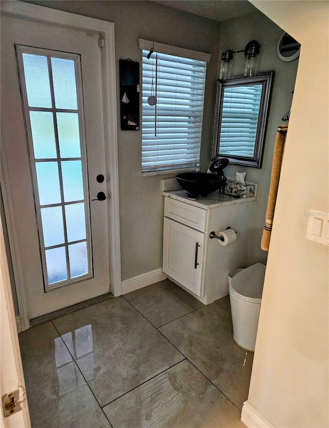 bathroom featuring tile patterned flooring, vanity, toilet, and a wealth of natural light