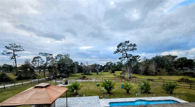 view of swimming pool featuring a rural view