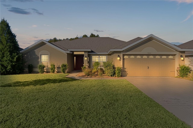 ranch-style home with a yard and a garage