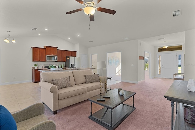 carpeted living room featuring ceiling fan with notable chandelier and high vaulted ceiling