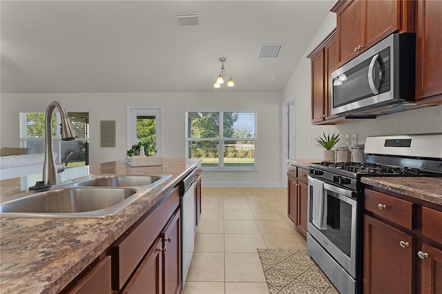 kitchen featuring a healthy amount of sunlight, sink, light tile patterned floors, and stainless steel appliances