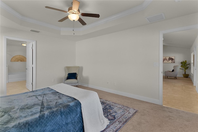 carpeted bedroom featuring a tray ceiling, ensuite bathroom, crown molding, and ceiling fan