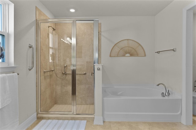 bathroom featuring tile patterned flooring, shower with separate bathtub, and toilet