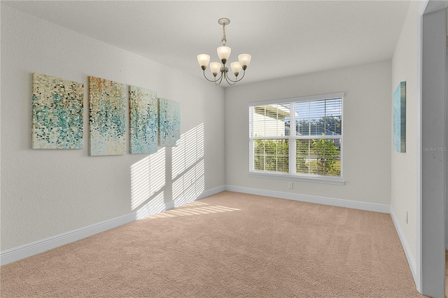 carpeted empty room featuring a chandelier