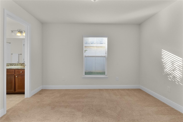 empty room featuring light colored carpet and sink