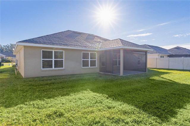 back of house with a lawn and a sunroom