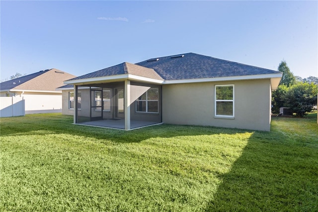 back of house with a sunroom and a lawn