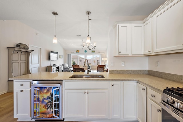 kitchen featuring pendant lighting, an inviting chandelier, sink, wine cooler, and kitchen peninsula