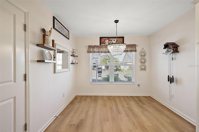 unfurnished dining area featuring light hardwood / wood-style flooring and an inviting chandelier