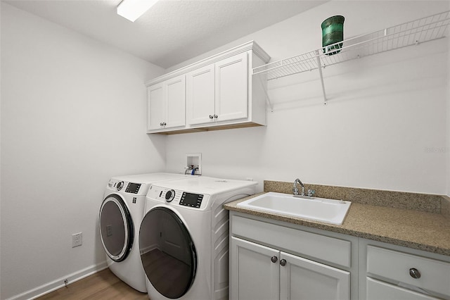 washroom with washer and clothes dryer, dark hardwood / wood-style flooring, sink, and cabinets