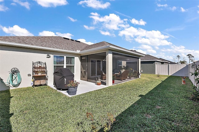 back of property with a yard, a patio, and a sunroom