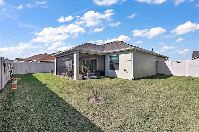 rear view of property with a yard and a sunroom