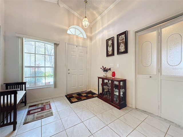 tiled foyer featuring a textured ceiling and crown molding