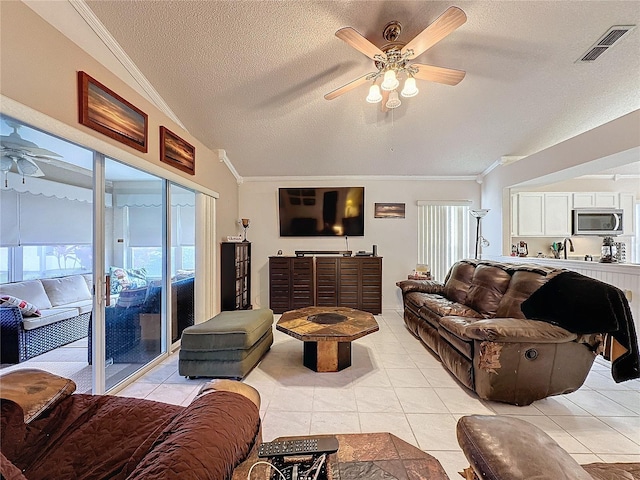 tiled living room with ceiling fan, a textured ceiling, and vaulted ceiling