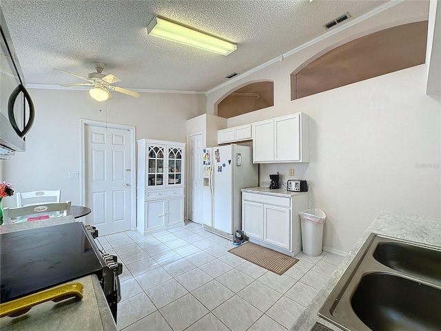 kitchen featuring white cabinetry, white fridge with ice dispenser, ornamental molding, and sink