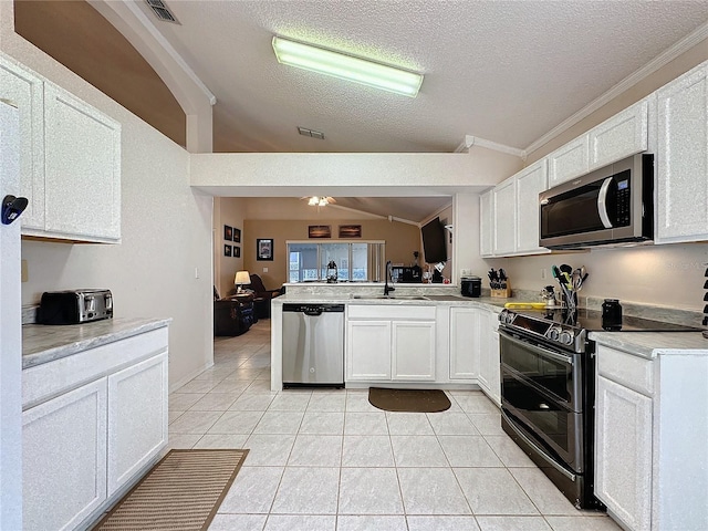 kitchen with kitchen peninsula, appliances with stainless steel finishes, a textured ceiling, and white cabinetry