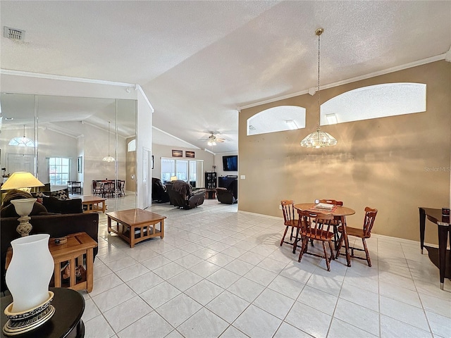 dining space with ceiling fan, crown molding, light tile patterned flooring, and lofted ceiling