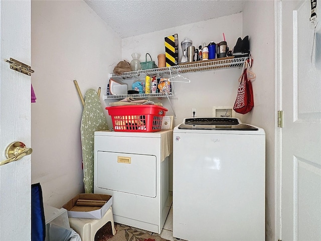 laundry room featuring washing machine and dryer and a textured ceiling