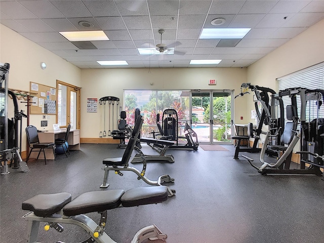 exercise room with a drop ceiling and ceiling fan