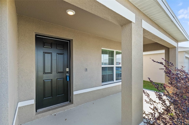 view of exterior entry with a porch