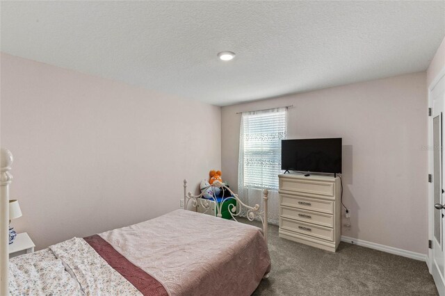 bedroom with carpet floors and a textured ceiling