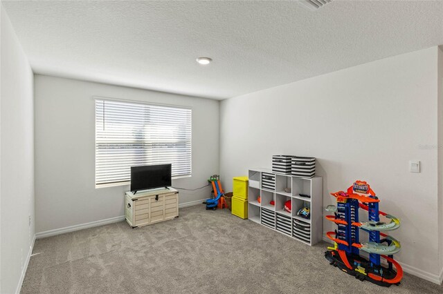 playroom featuring carpet and a textured ceiling