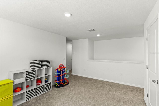 playroom with light carpet and a textured ceiling