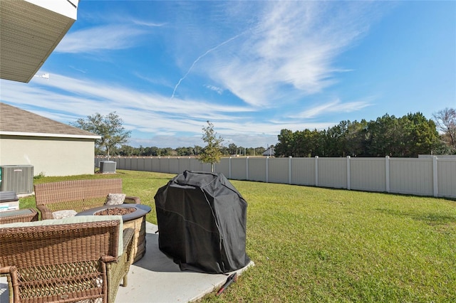 view of yard with central AC and a fire pit