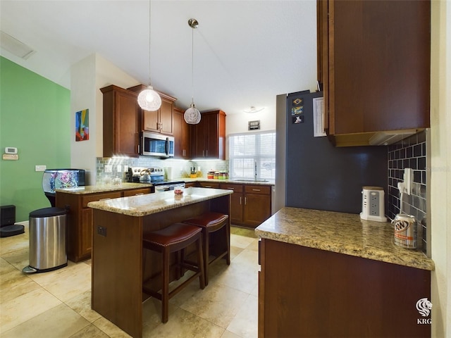 kitchen with a center island, backsplash, sink, appliances with stainless steel finishes, and decorative light fixtures