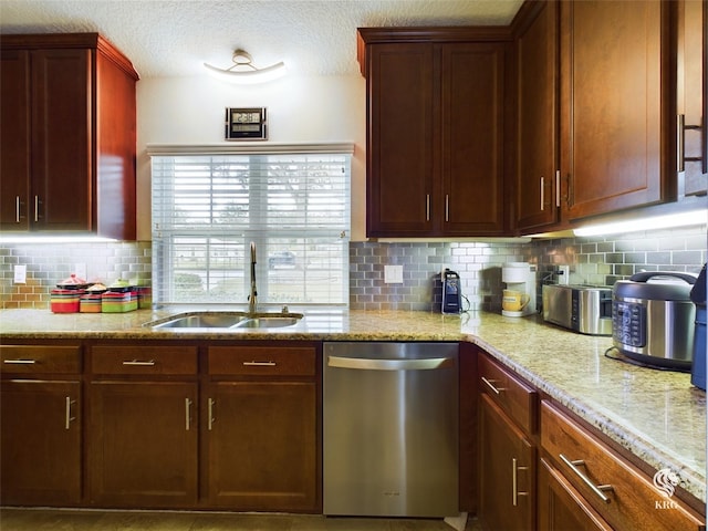 kitchen featuring decorative backsplash, sink, stainless steel dishwasher, and light stone counters