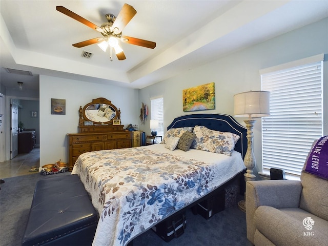 tiled bedroom featuring a raised ceiling and ceiling fan