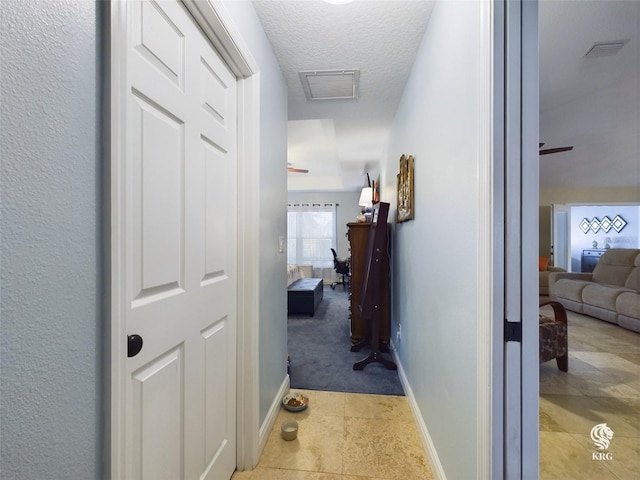 hall featuring a textured ceiling