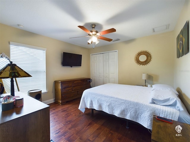 bedroom featuring dark hardwood / wood-style flooring, ceiling fan, and a closet