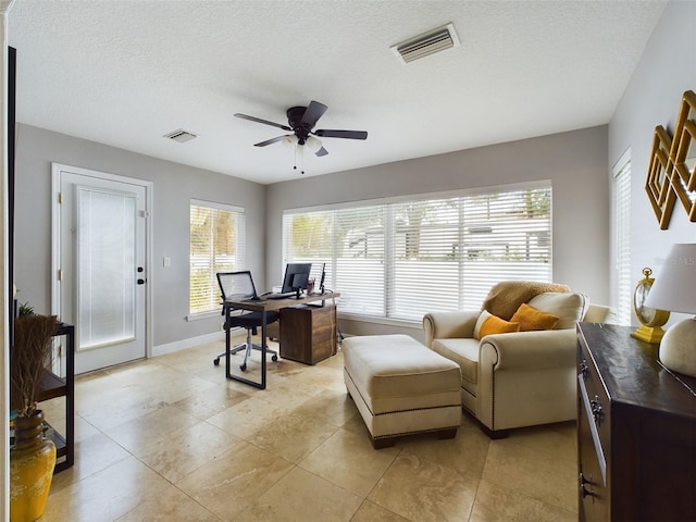 home office with ceiling fan, a wealth of natural light, and a textured ceiling