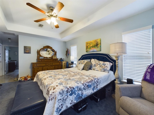 bedroom featuring a raised ceiling and ceiling fan