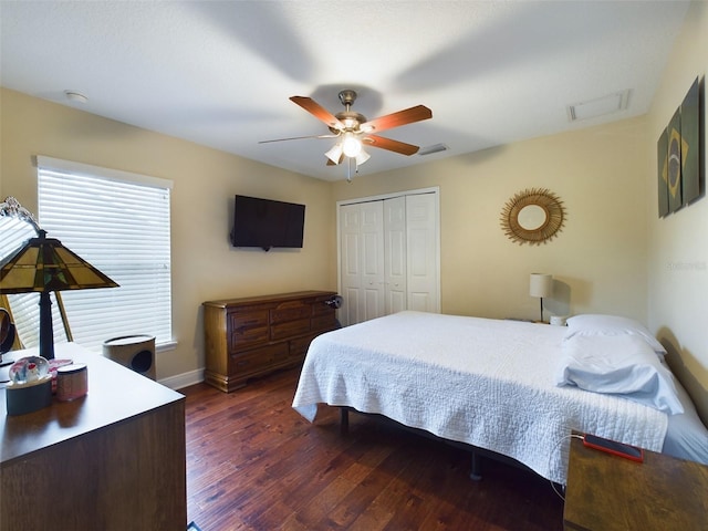 bedroom with dark hardwood / wood-style floors, ceiling fan, and a closet