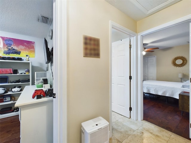 corridor featuring light tile patterned floors and a textured ceiling