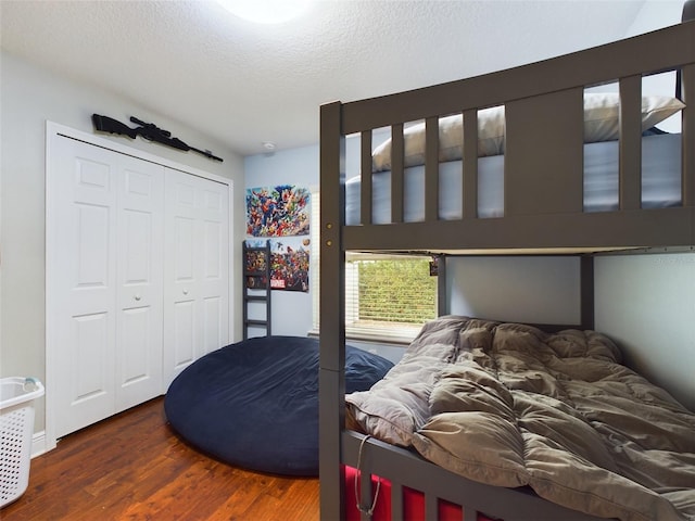 bedroom with dark wood-type flooring, a closet, and a textured ceiling