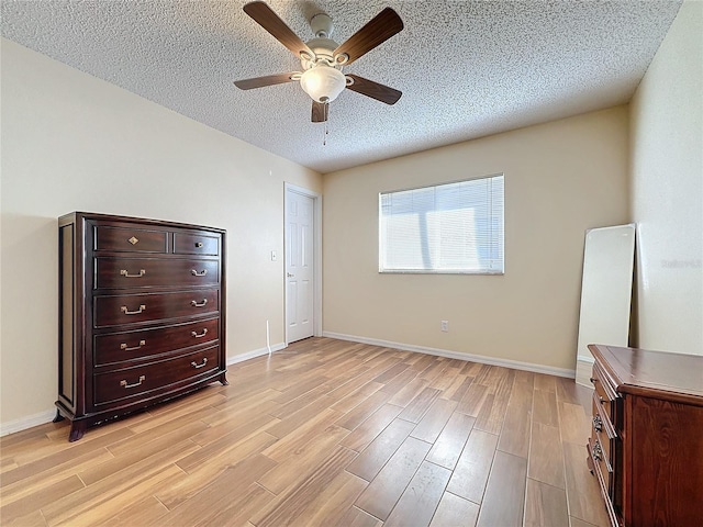 bedroom featuring a textured ceiling, light hardwood / wood-style flooring, and ceiling fan