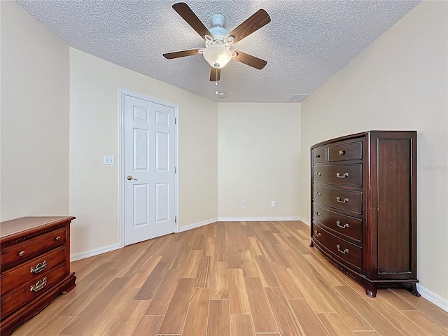 bedroom with ceiling fan, light hardwood / wood-style flooring, and a textured ceiling