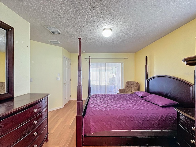 bedroom with light hardwood / wood-style floors and a textured ceiling