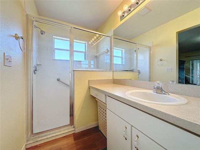 bathroom featuring vanity, wood-type flooring, and walk in shower