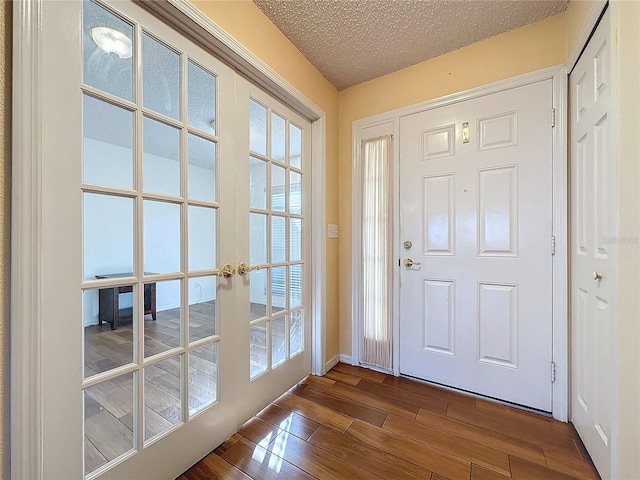 foyer featuring plenty of natural light, french doors, and a textured ceiling